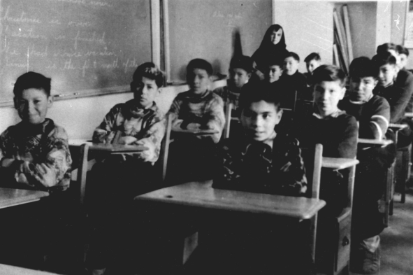 Students of the residential school at Fort Albany in class under the supervision of a nun, around 1945